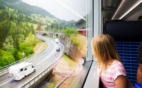 Ragazza che viaggia in treno e guarda fuori dal finestrino