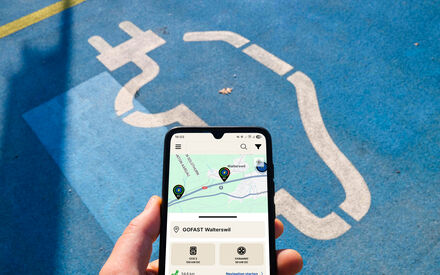 Hand hält Smartphone mit geöffneter eCharge App.